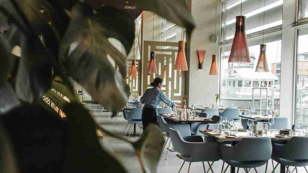 woman in front on brown dining table in pizza hutand chairs inside building