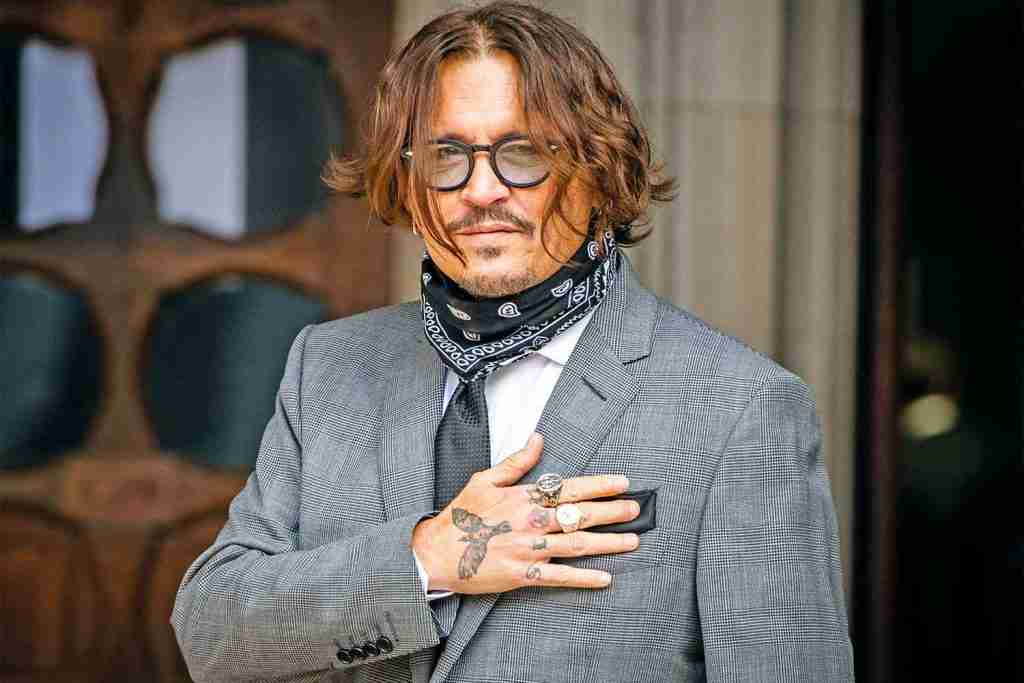 Johnny-Depp holding his hand on chest. 