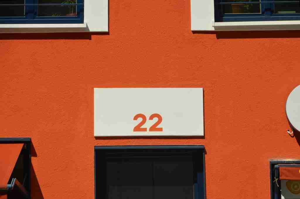 Number 22 written Orange on White wall 