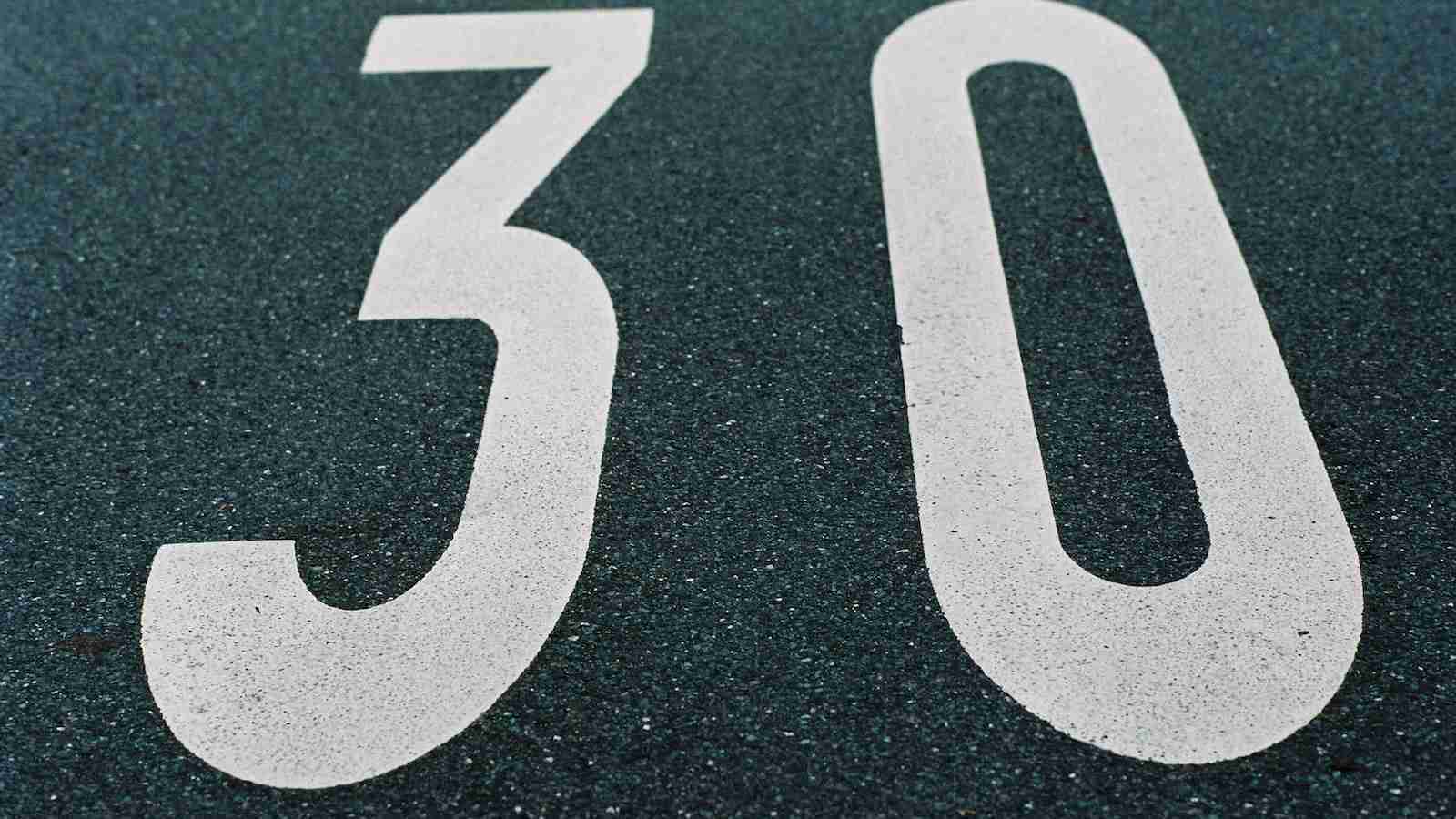 black and white number 30 written on a road