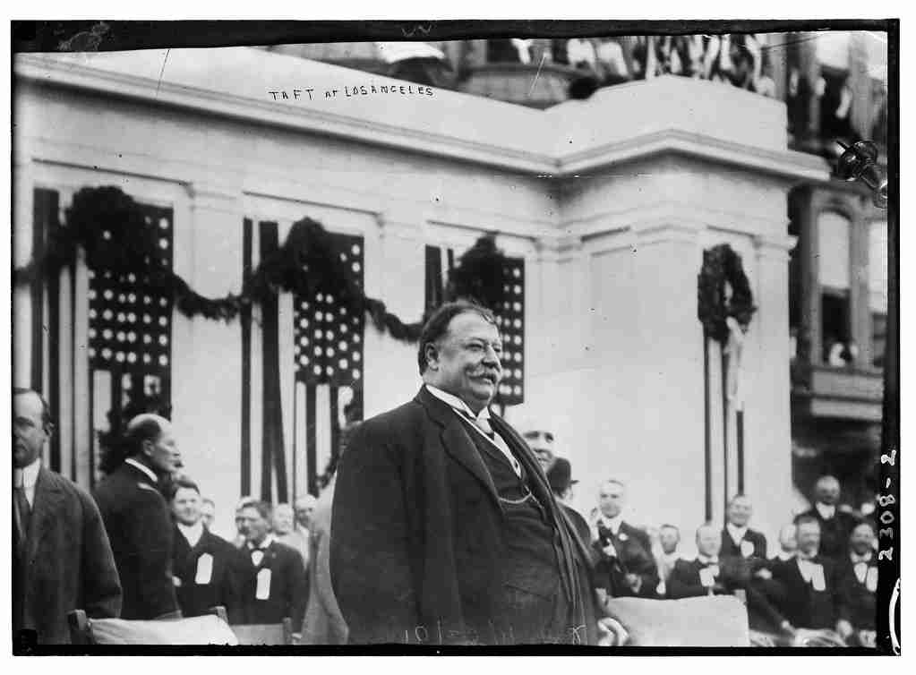 William Howard Taft standing in front of a building