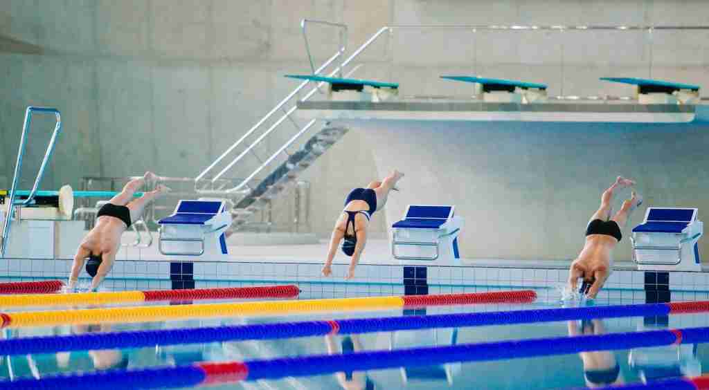 Image of three swimmers jumping on swimming pool : Fun Facts About Swimming