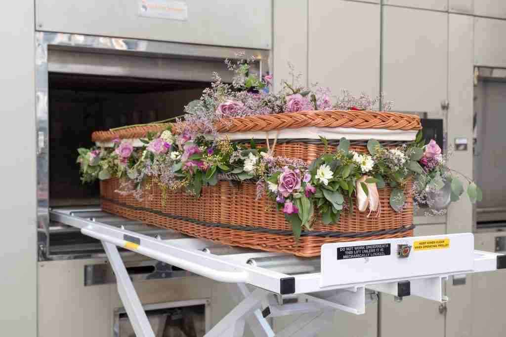 a wicker basket with flowers in it on a conveyor belt