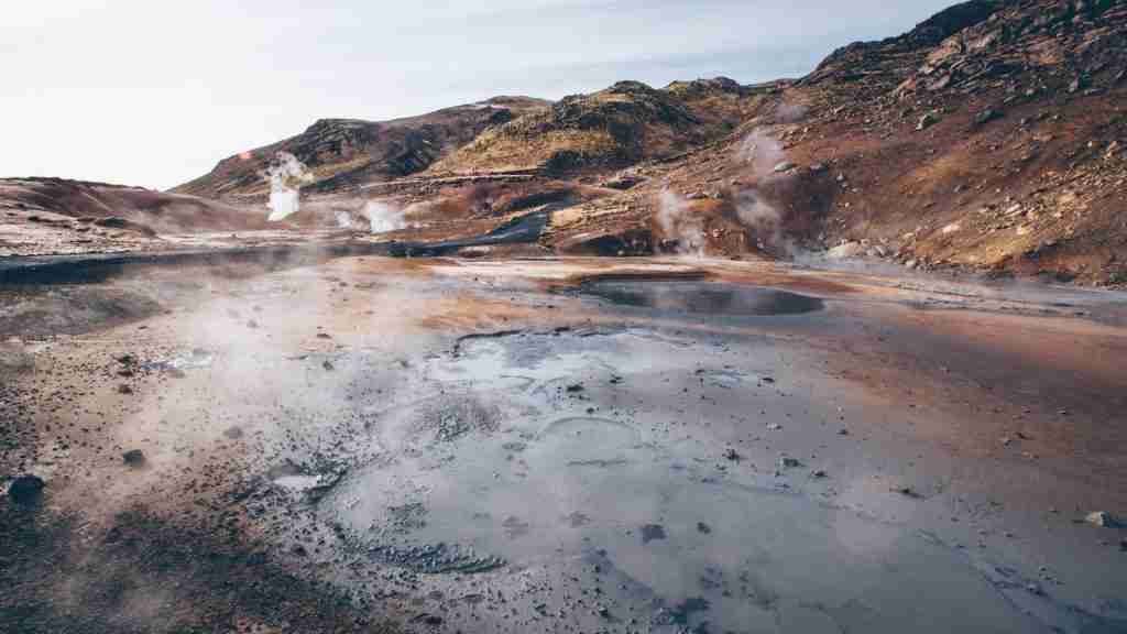 volcano crater emitting smoke during daytime