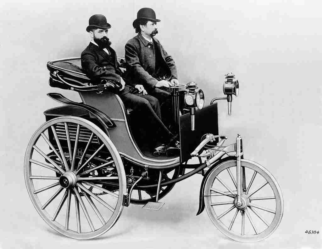 two people on an old motor car