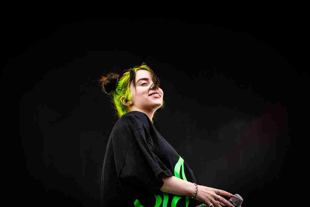 Billie Eilish poses in a portrait with a black background, capturing the essence of fun facts about Billie Eilish.