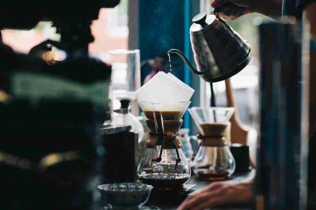 Barista pouring coffee into a glass container another Fun facts about coffee.