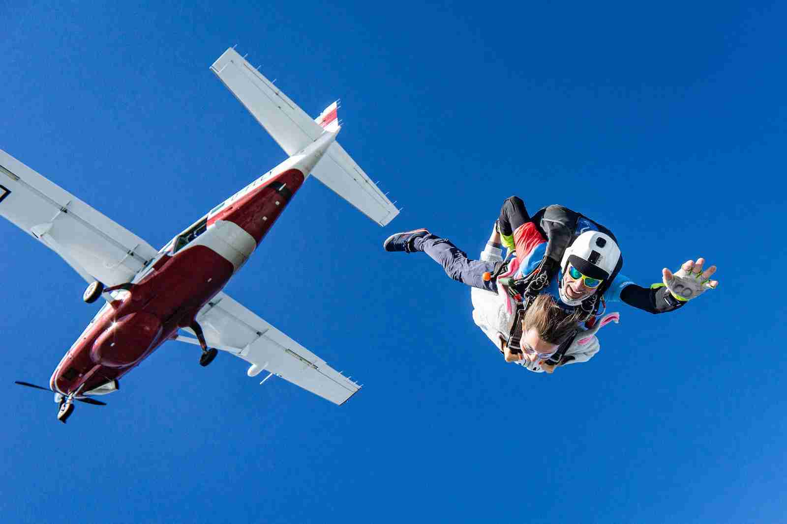 white and red airplane in mid air during daytime