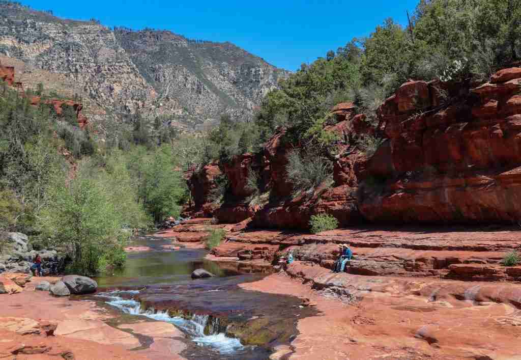 a group of people standing on the side of a river