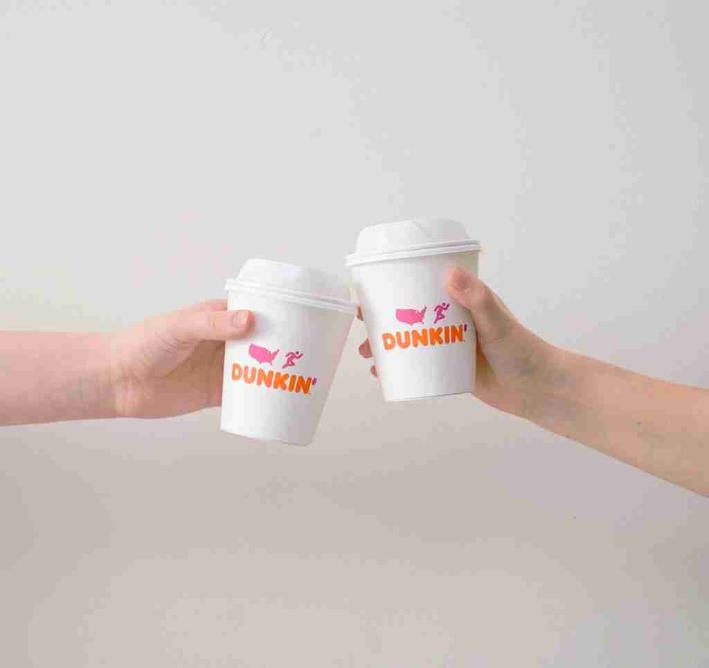 two people with white Dunkin' Donuts paper cups