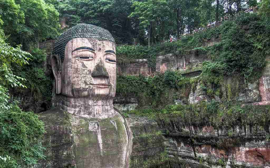 Stone-carved giant statue adorned with lush greenery – uncovering interesting facts about China's cultural marvels.