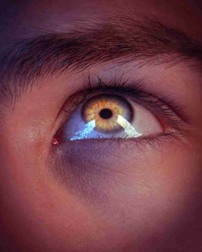 a man's eye with the reflection of an eyeball in it