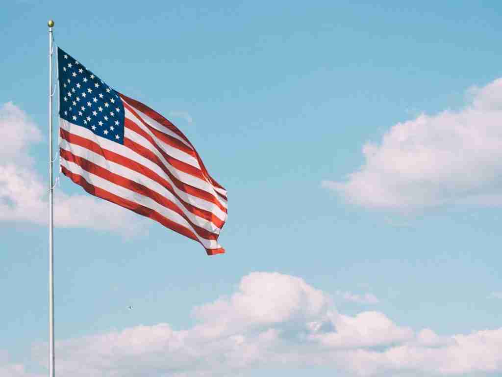 The American flag flying under white clouds during the daytime. Fun facts about the color red: Exploring its significance and symbolism.